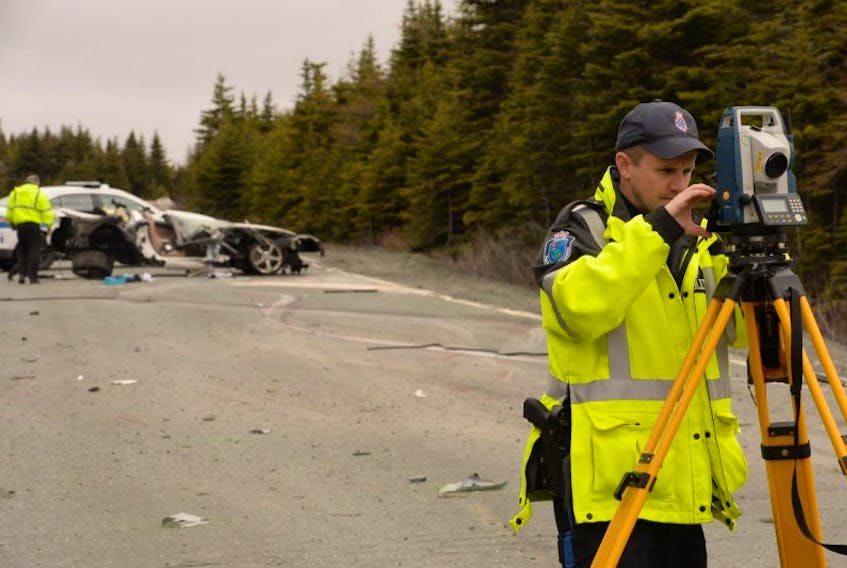 RNC traffic services section officer Const. Colin Deacey conducts his investigation into the cause of a serious collision on Blackhead Road in Shea Heights Wednesdayas he plots points of the roadway.