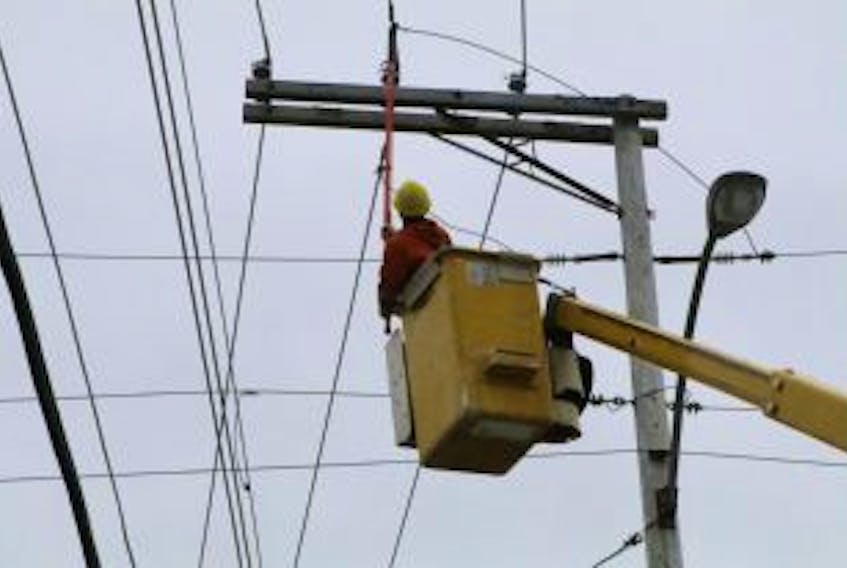 ["Newfoundland Power crews restore power that had been cut off on Monroe Street in St. John's to allow firefighters to safely deal with a fire at No. 52."]