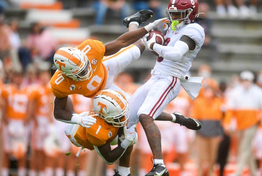Tennessee defensive backs Bryce Thompson (0) and Trevon Flowers tackle Alabama wide receiver John Metchie at Neyland Stadium in Knoxville, Tenn., on Oct. 24, 2020.   