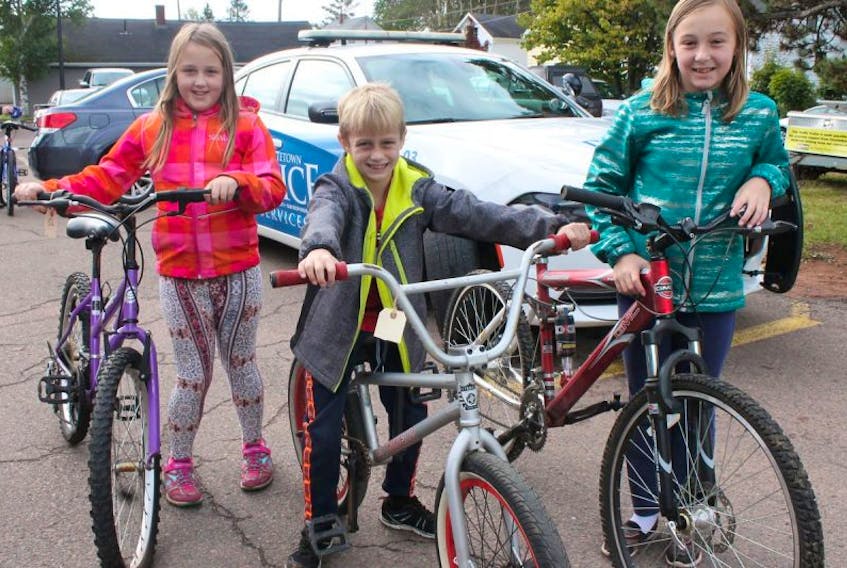 Siblings, from left, Erika, Reese and Jordan Kennedy show the bikes their father Thane bought them during the Charlottetown Police bike auction on Saturday. Reese was also celebrating his eighth birthday on the day of the auction.