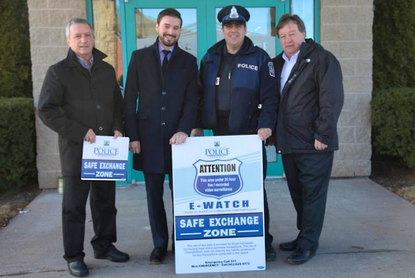 From left, Coun. Kevin Ramsay, chair of the Charlottetown Youth Retention Advisory Board; Zac Murphy, member of the Youth Retention Advisory Board; Const. Trevor Monaghan, Charlottetown Police Services; and Charlottetown Mayor Clifford Lee pose with the signage for eWatch Safe Exchange Zone.