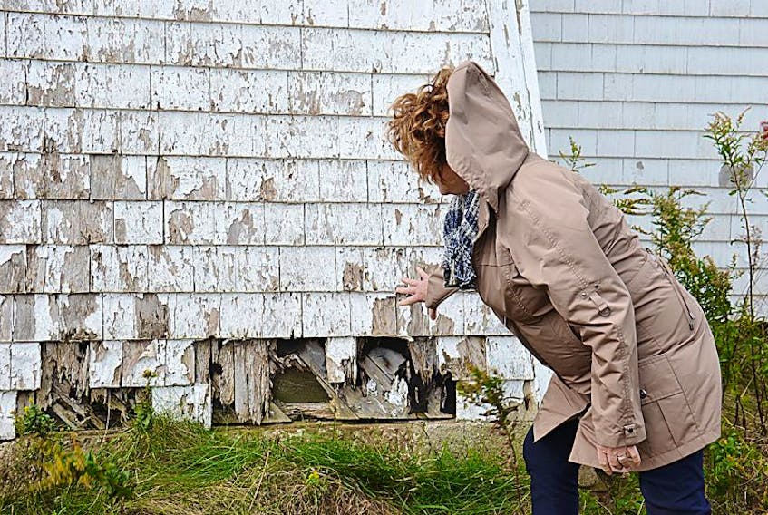 Carol Carragher shows the damage to the Blockhouse Point Lighthouse in Rocky Point that she would like to see repaired.