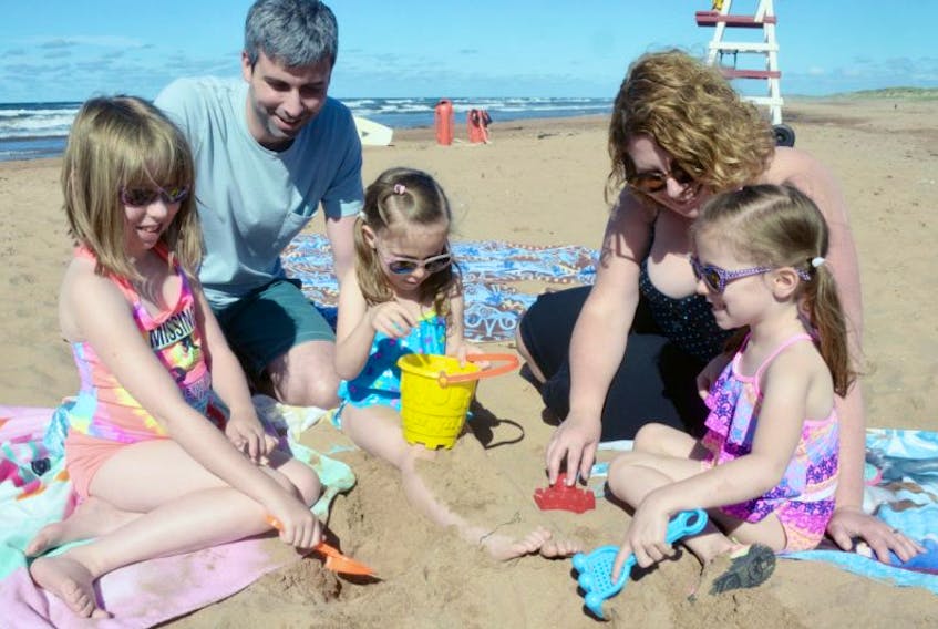 Sisters, from left, Emilie, Katie and Lisa Ward play with their uncle Chris and aunt Jennifer during a visit to Brackley Beach. - File