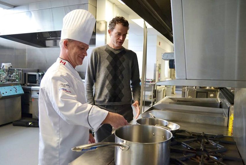 Chef Kevin Boyce, left, and comedian Patrick Ledwell look over some of the cooking implements at the Culinary Institute of Canada in Charlottetown. Ledwell is the host for the evening’s activities.