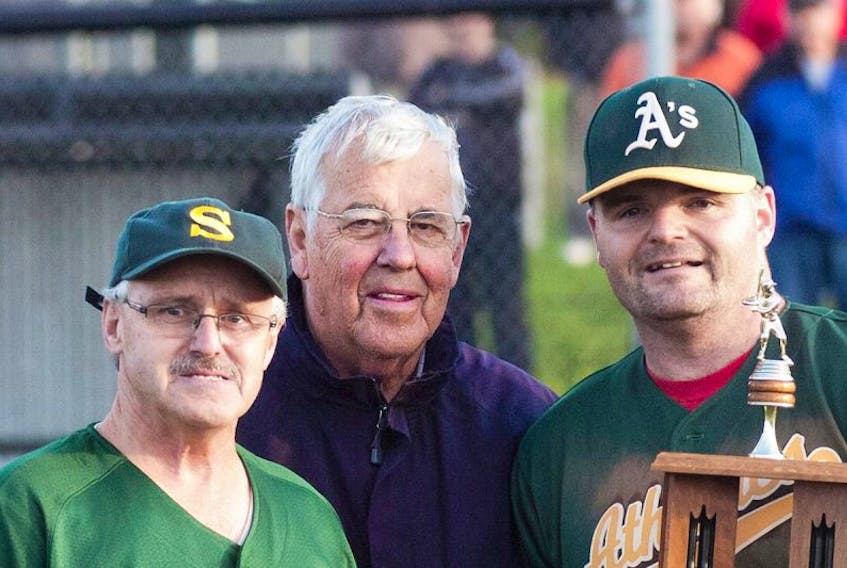 BRIAN MCINNIS/TC MEDIA/ARCHIVE 
 The late Aquinas Ryan, centre is seen presenting the 2012 championship trophy in his role as the then president of the Kings County Baseball League. With him are members ot that year's winning team, the Stratford 3 Points Machining and Aerospace Athletics.