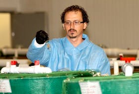 Aquaculture Technologist I, Leonard Kortekaas, feeds tilapia at the Center for Aquaculture Technologies Canada (CATC) facility in Souris. The company recently received CFIA approval for its biosafety level-three containment lab.