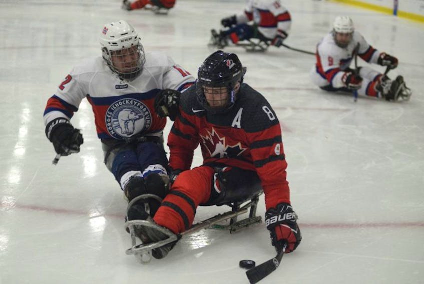 Team Canada's Tyler McGregor shields the puck from Norway's Magnus Bogle during Thursday's World Sledge Hockey Challenge semifinal.