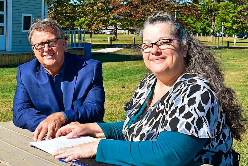 Playwright Linda Wigmore shares her script with Education, Early Learning and Culture Minister Doug Currie at the Victoria Park cultural pavilion.