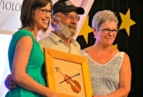 Carole Gallant, left, and Caroline Arsenault, present the Golden Fiddle Award to Jacques Arsenault during the Atlantic Fiddlers’ Jamboree recently.