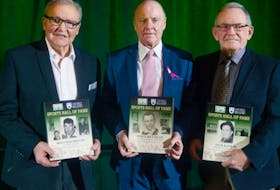 Former Saint Dunstan’s University hockey players, from left, Billy MacMillan, Vince Mulligan and Jack Kane Jr. show the plaques given to them during the UPEI Sports Hall of Fame induction ceremony on Saturday. John “Jack” Hurry Kane was also honoured posthumously at the event after leading Saint Dunstan’s to its first Maritime League title in 1947.