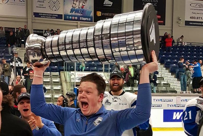 Saint John Sea Dogs equipment mananger Tyler Jay raises the Presidents Cup after the Sea Dogs won the Quebec Major Junior Hockey League title on Wednesday.