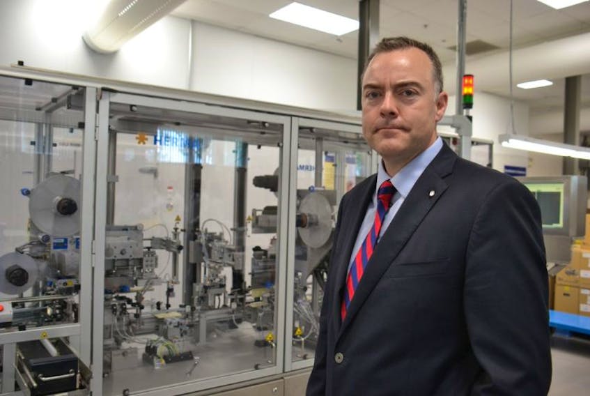 Brian Stewart, Sekisui Diagnostics’ director of manufacturing, shows off an automatic filling and labelling machine during a tour of the company’s expanded facility on Tuesday.