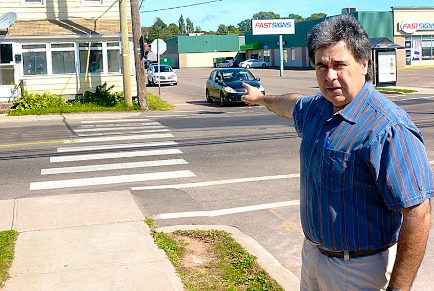 Coun. Mitch Tweel points to an intersection he describes as a “death trap” at Queen and Pond streets in Charlottetown. Tweel is calling on council to adopt a number of recommendations made in a 2010 report, which recommends moving or relocating the house on the corner. The house extends past the Pond Street stop sign, giving drivers no visibility unless they extend past the sign.