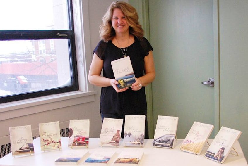 Award-winning Summerside author and filmmaker Susan Rodgers, holds up her latest and book in the Drifter series “Watch Over Me” during a book reading at the Summerside Rotary Library on Saturday afternoon.