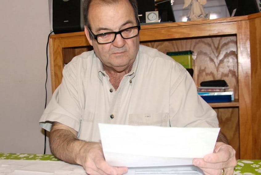 Michael Arsenault of Charlottetown looks over some documents dealing with his workplace injury in March. Arsenault is fighting for continuation of workers' compensation coverage that was halted in June.