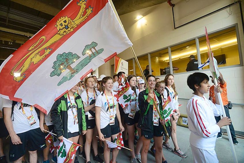 Alexa McQuaid carries the flag into the closing ceremonies at the Canada Games Sunday in Winnipeg.
