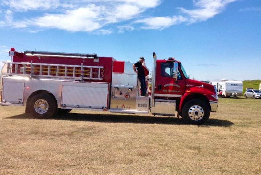 ["Miminegash Fire Department's new fire truck arrives with Santa on board during the Miminegash Fire Department's annual summer festival on Saturday."]