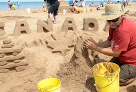 Island artist Maurice Bernard works on a massive sandcastle celebrating Canada 150.