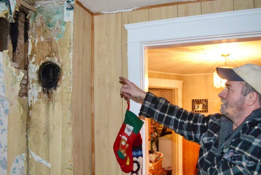 Alfred Culleton points to an area near the ceiling in his living room where a flue fire broke through and caused some structural damage and extensive smoke damage to his familyâs Elmsdale home.