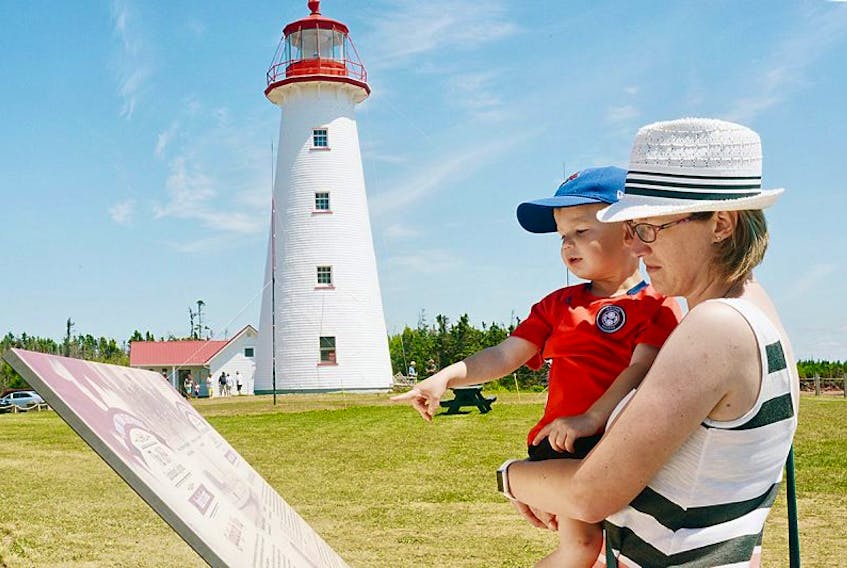 Julia Routley and her son Owen, of Ontario, read some of the history of the Point Prim Lighthouse while visiting the structure this past weekend. An open house was held at the lighthouse on Saturday to celebrate a recent revitalization to the structure since a local group took over ownership.