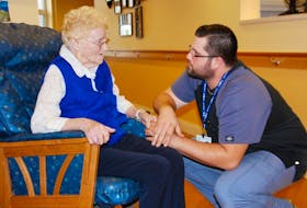 Kaelin Fisher, a resident care worker at Prince Edward Home, offers some warm interaction with resident June Connolly. Fisher recently received a special award recognizing his person-centred care.