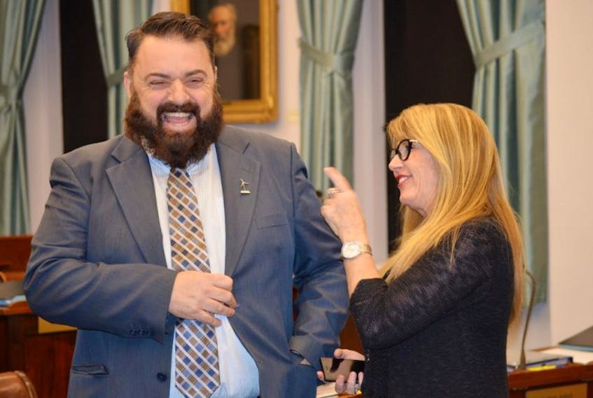 Hal Perry, MLA for Tignish-Palmer Road, shares a laugh with Tina Mundy, Minister of Family and Human Services, in the legislature on Thursday. Perry inquired during question period whether or not more wind opportunities would present themselves with the new cables from P.E.I. to N.B.