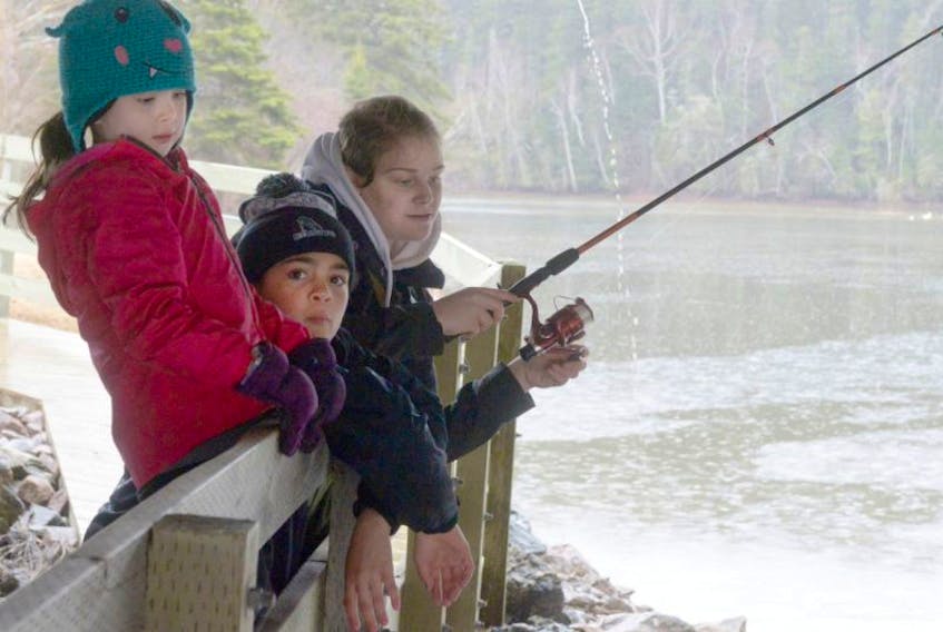 Alishia Kinsman shows her nieces Shelby, 11, and Memphis, 6, Weir-Masters how to fish while in Bonshaw on April 16, 2017.