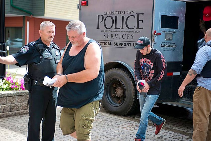 Some of the nine men arrested by police in Charlottetown Wednesday night and are said to be associated with the Hells Angels are escorted into the provincial court Thursday. They are all facing multiple charges, including running an allegedly illegal lottery scheme.