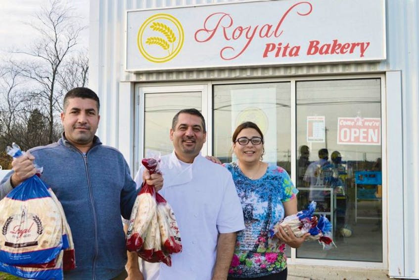 Ismail Alahmad, left, a Syrian refugee now living in Charlottetown, has become a regular at Royal Pita Bakery. During The Guardian’s visit he purchased 20 bags of pita bread, some of which he displays here. Toufic and Maud Houchane, centre and right, moved from Lebanon to Charlottetown in 2006 and opened the bakery earlier this year in Charlottetown.