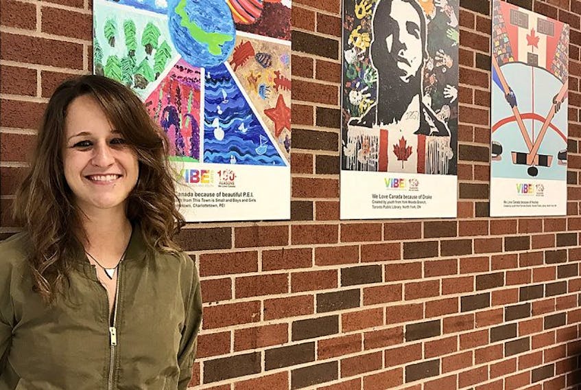 Artist Ashley Anne Clark stands in front of P.E.I.’s submission for the “150+ Reasons We Love Canada” initiative, which is a showcase of murals created by youth from every province in recognition of Canada’s 150th birthday. This Town is Small commissioned Clark to work with the Boys & Girls Club of Charlottetown to develop the P.E.I. submission, which is on display at the Charlottetown airport.