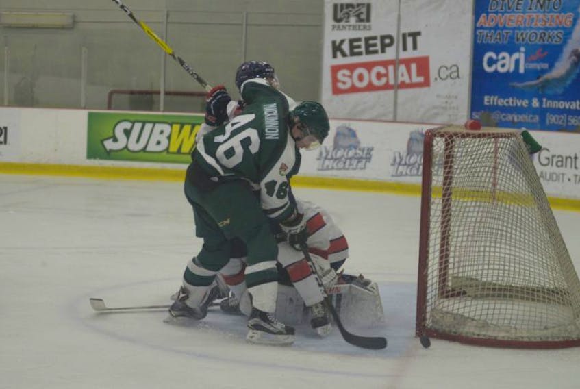 UPEI Panthers defenceman Ryan MacKinnon tries to corral a loose puck while battling Acadia Axemen defenceman Tyler Ferry to the side of goalie Robert Steeves Friday at MacLauchlan Arena.