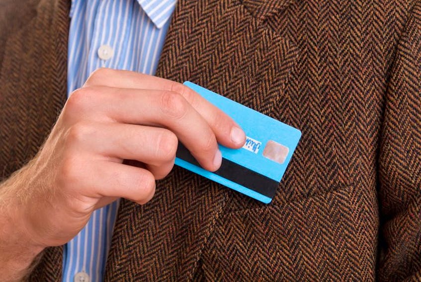 File photo of a credit card in hand.