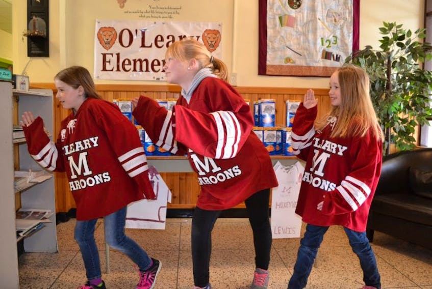 O’Leary Elementary students Kassandra MacDonald, left, Olivia Dumville and Ellie Lewis strike a pose recently. It’s in reference to their parents needing to confirm they are not robots each time they cast their online Kraft Hockeyville votes for O’Leary.
