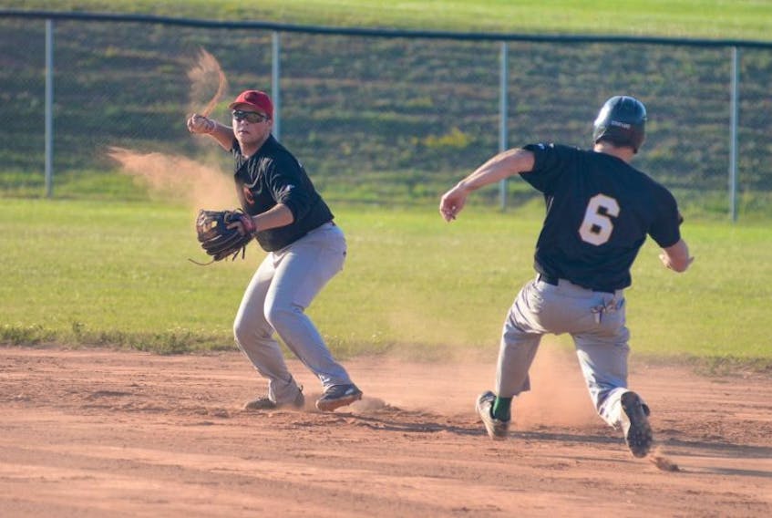 Morell Chevies shortstop Logan Gallant, left, thinks about throwing to first as Randy Taylor, of The Alley Stratford Athletics, tries to break up a double-play attempt during Kings County Baseball League action.