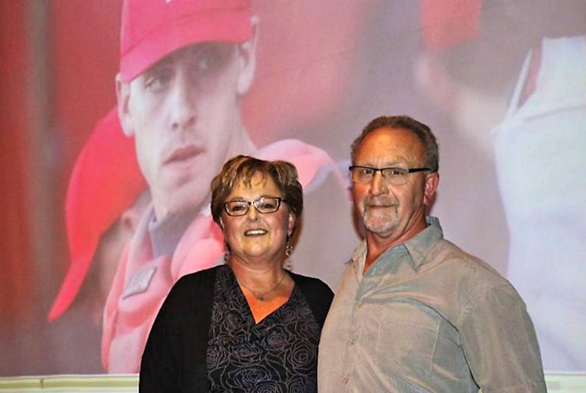 Dianne MacLean and her husband, Irwin, stand on stage before their presentation about their son, Mitch, seen in the image behind them. Dianne MacLean was the guest speaker at the International Childrenâs Memorial Place fundraising dinner this past weekend.