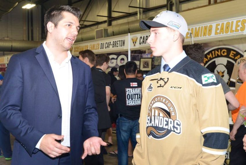 Charlottetown Islanders ambassador Jimmy Bonneau, left, speaks with the Isles second-round Nathaniel Doyon during the 2016 draft in Charlottetown.