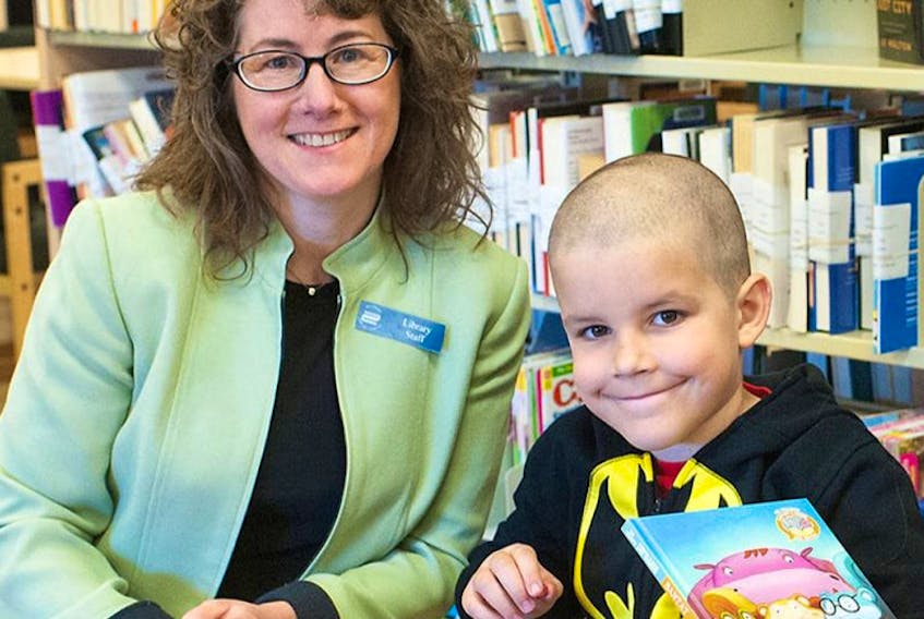 Cornwall librarian Pam Wheatley and Colton DesRoches hang out and do some reading at the  Cornwall library recently. The P.E.I. government has announced that Island families will no longer have to pay fines on overdue children’s materials beginning June 1.