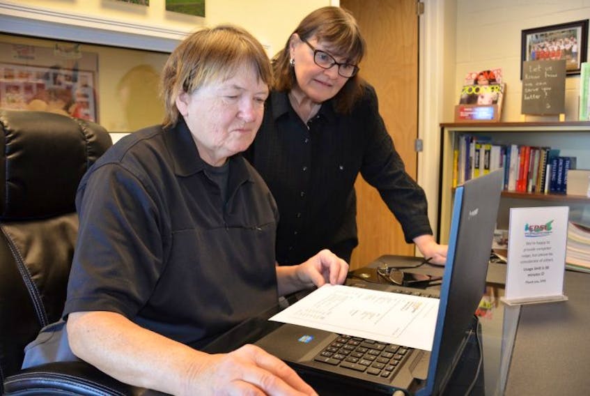 Lorraine MacDonald, left, receives help on the EPSI computer from the program’s executive director Gloria Schurman.