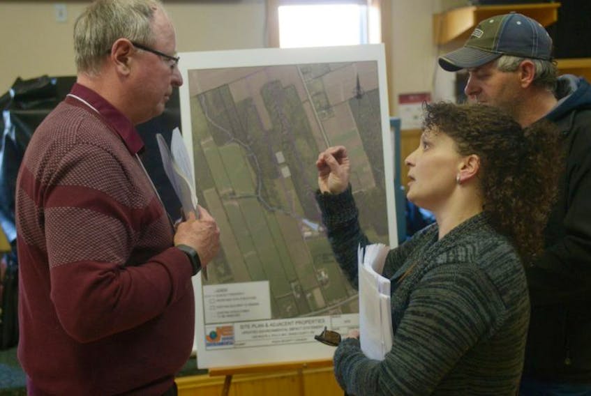 Dawn and Stephen Carter ask consultant Don Jardine, left, some questions about the proposed AquaBounty expansion in Rollo Bay during a public meeting last night at the Fortune Community Centre. The couple lives next to where two new proposed buildings would be constructed and have concerns over the effect