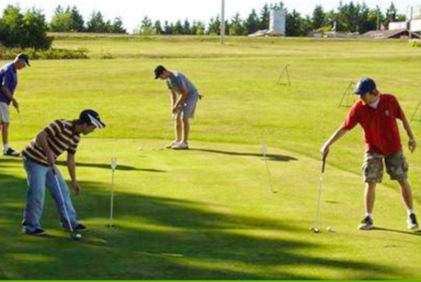 Golfers practice their putting on a green at Strathgartney Highlands Golf Course.