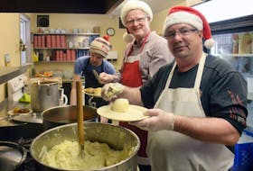 Paul Brown, right, and Ian Reid, left, were two of the many volunteers helping to serve a Christmas meal at the Upper Room soup kitchen this afternoon.