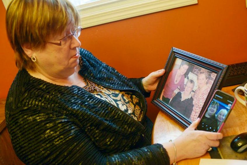 Stratford resident Frances Lamoureux looks over some pictures of herself with her sisters after spending years trying to re-connect with her many siblings. Having grown up in foster care, Lamoureux has since met with or spoken to 11 of her 13 siblings and is now searching for the final two, a brother named Joseph William Gerard and sister named Claudia Ann.