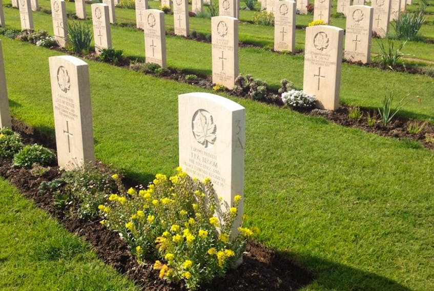 White headstones marking the graves of Canadian soldiers killed in the First World War gleam in the summer sun in a cemetery in Europe.