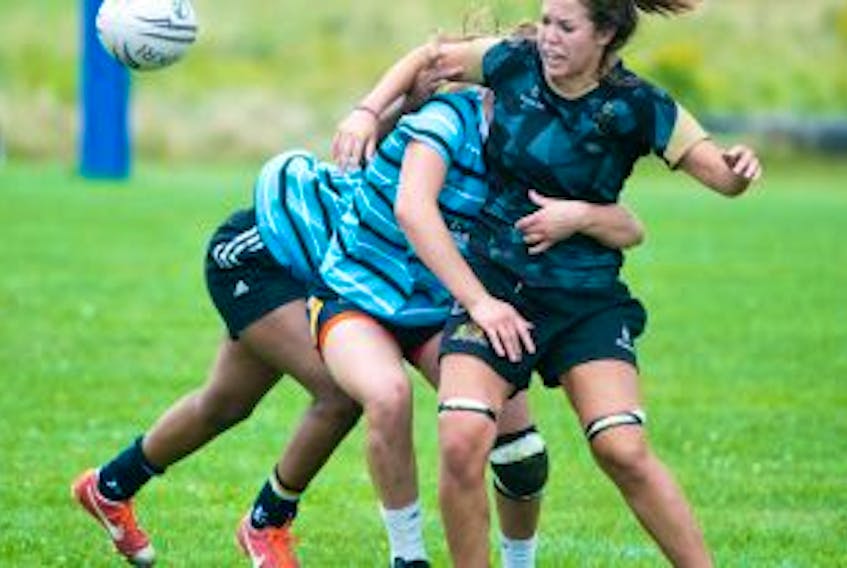 ['Charlottetown Rugby Football Club’s Megan Larkin loses the ball when she is hit by a member of the Halifax Tars Saturday in Charlottetown.']