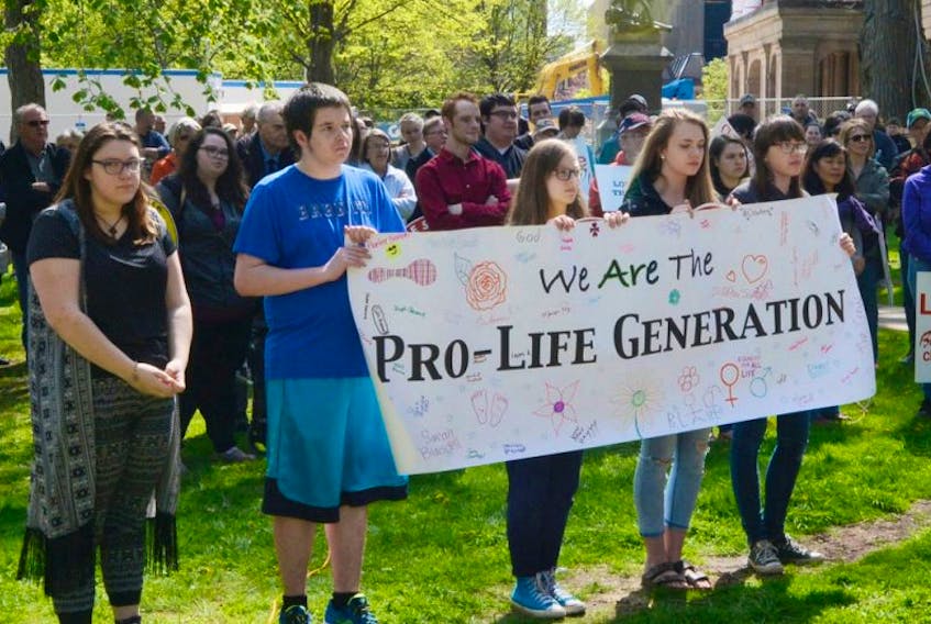 Young Islanders in the March for Life hold up a sign during a rally in front of the Coles Building on Sunday. The group said there “has never been a more important time” to share their message.