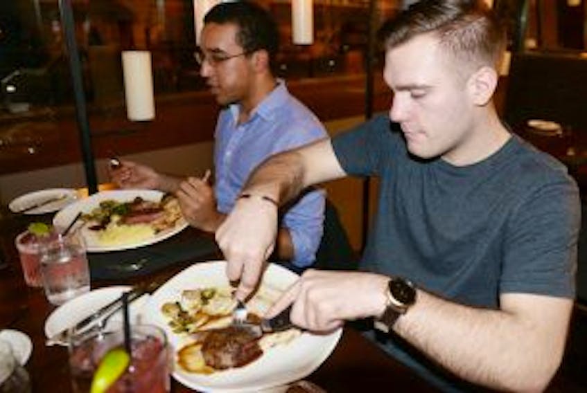 ['Marcus Wright, right, and Adrian Brown dig into some steaks at The Barrington Steakhouse and Oyster Bar in Halifax.']
