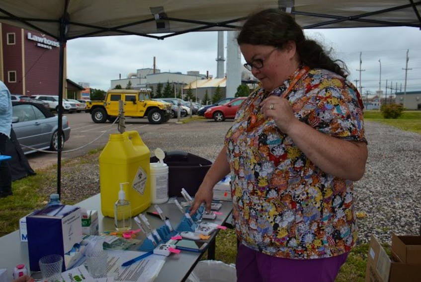 Vanessa Arseneau, chief technologist for microbiology at the Queen Elizabeth Hospital, checks blood samples being tested for hepatitis C during an AIDS P.E.I. event Friday in Charlottetown.
