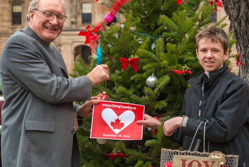 P.E.I. Premier Wade MacLauchlan and Nathan Ryan, 16, of Charlottetown decorate a Christmas tree to celebrate Giving Tuesday, which is being held today, as a day for giving back. Ryan, who is a cancer survivor, is helping the Queen Elizabeth Hospital decorate as a way to say thanks for the care he received.