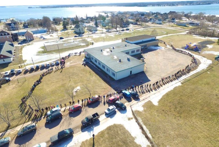 Hundreds of individuals link hands and form a human chain around Georgetown Elementary on Sunday as a way to send a message to the province, which has slated the school as one of five that could close by the end of this year.