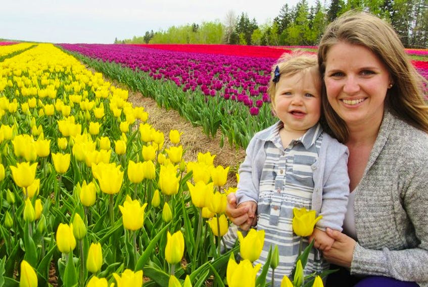 Jessica Sheppard of Winsloe and her daughter, Charlie, kneel at the edge of a vast field of tulips in Dromore.